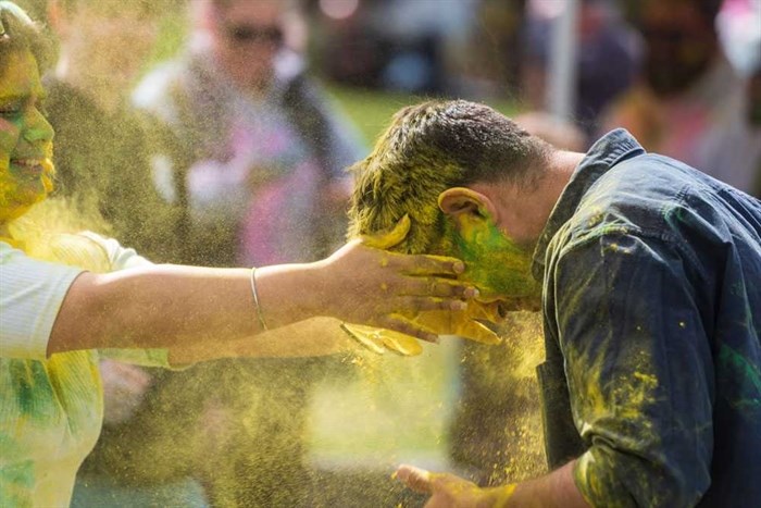 Participants douse one another in yellow and green powder at the Holi Festival in Riverside Park in Kamloops. 