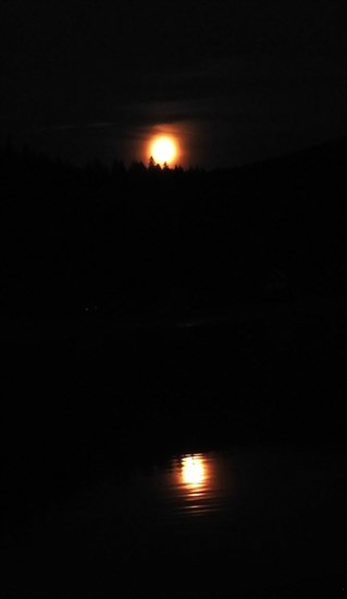 The reflection of the full Pink Moon is seen in Pinantan Lake near Kamloops. 