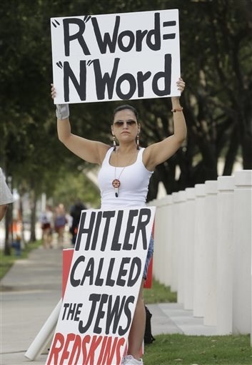 A woman protests against the Washington Redskins mascot name outside NRG Stadium before an NFL football game between the Washington Redskins and Houston Texans, Sunday, Sept. 7, 2014, in Houston.