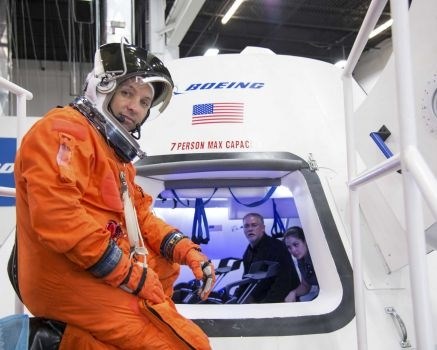 In this undated image provided by NASA, astronaut Randy Bresnik prepares to enter The Boeing Company's CST-100 spacecraft for a fit check evaluation at the company's Houston Product Support Center. On Tuesday, Sept. 16, 2014, NASA will announce which one or two private companies wins the right to transport astronauts to the International Space Station. The deal will end NASA's expensive reliance on Russian crew transport. The contenders include SpaceX, Sierra Nevada Corp., and Boeing.