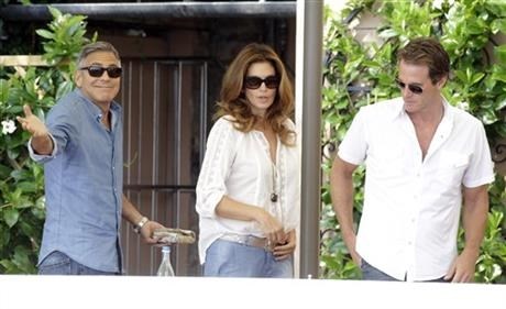 George Clooney, left, Cindy Crawford and her husband Rande Gerber walk in the garden of the Cipriani hotel in Venice, Italy, Saturday, Sept. 27, 2014.