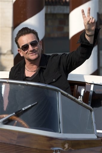 Bono Vox gives the v-sign as he arrives at the Cipriani hotel in Venice, Italy, Saturday, Sept. 27, 2014.
