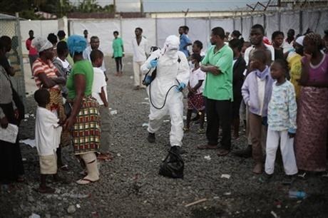 A medical worker sprays people being discharged from a treatment center in Monrovia, Liberia.