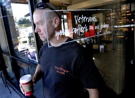 Arizona Air National Guard Lt. Col. Greg Grattop exits a Starbucks with his free coffee, Tuesday, Nov. 11, 2014 in Chandler, Ariz. 