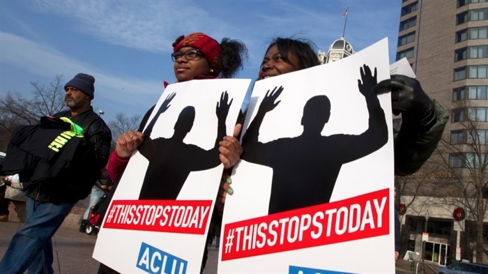 Melissa W. Green, right, and her daughter, Reshae Green, hold up their signs at Freedom Plaza during the Justice for All march and rally on Pennsylvania Avenue in Washington on Saturday, Dec. 13, 2014. 