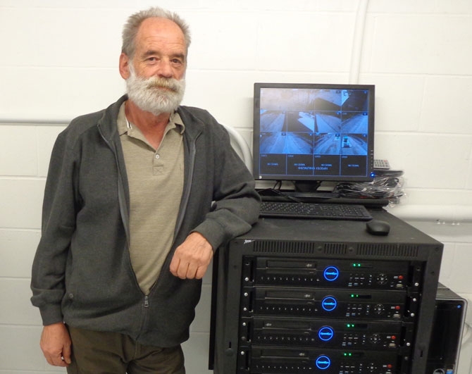 Potanicals' Cliff Stowell with a computer system that can store two years of video from 54 surveillance cameras.
