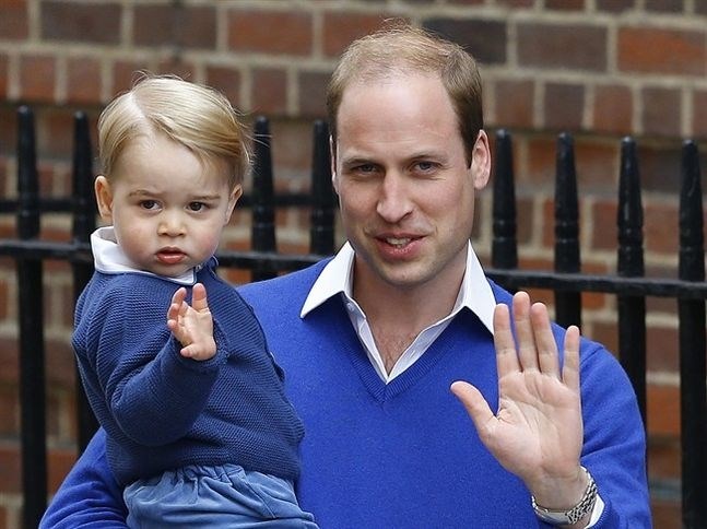 Britain's Prince William and his son Prince George wave as they return to St. Mary's Hospital's exclusive Lindo Wing, London, Saturday, May 2, 2015. William's wife, Kate, the Duchess of Cambridge, gave birth to a baby girl on Saturday morning.