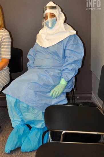 A volunteer demonstrates the protective gear those treating suspected Ebola cases must wear.