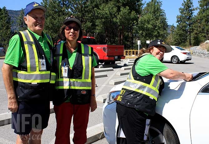 Community policing volunteers (from left to right) Nick Merluk, Carole Aoki and Sue McDougall issue auto crime prevention notices at Skaha Bluffs parking lot.