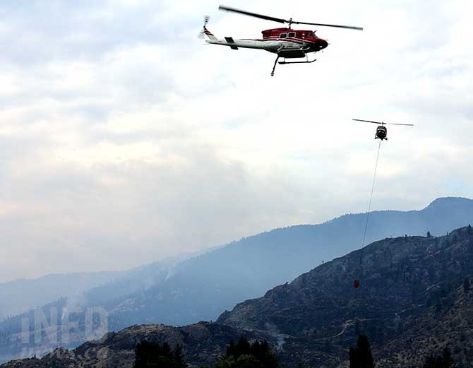 Helicopters bucket and snorkel out of Tuc El Nuit Lake in Oliver, Saturday, Aug. 15, 2015 in the fight against the Wilsons Mountain and Testalinden Creek wildfires.