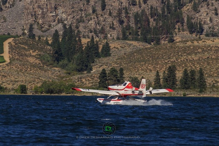 A Conair Fire Boss skimmer is filling up its water tanks on Osoyoos Lake before returning to fight the Testalinden Creek fire, Tuesday, Aug. 18, 2015.