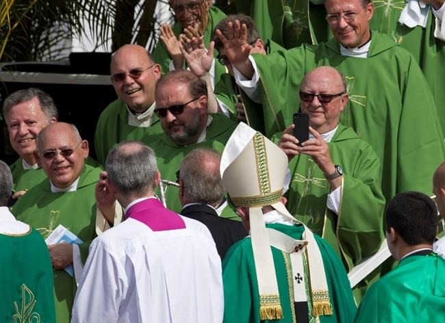 Clergy wave to and take pictures of Pope Francis after he celebrated Mass at Revolution Plaza in Havana, Cuba, Sunday, Sept. 20, 2015.