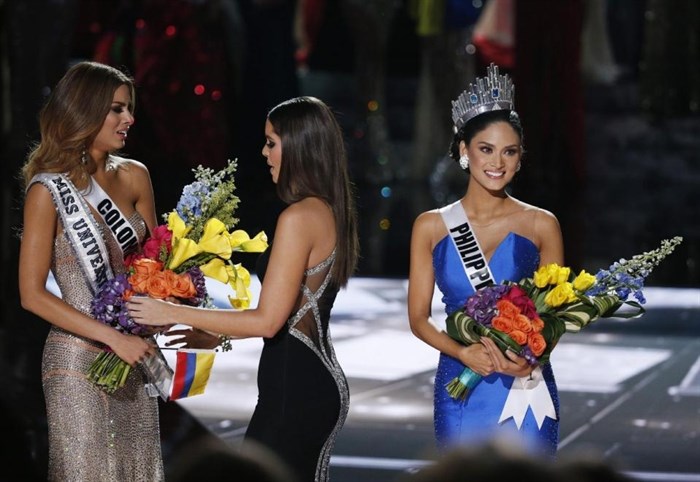 Former Miss Universe Paulina Vega, center, takes away the flowers and sash from Miss Colombia Ariadna Gutierrez, left, before giving it to Miss Philippines Pia Alonzo Wurtzbach, right, at the Miss Universe pageant Sunday, Dec. 20, 2015, in Las Vegas.