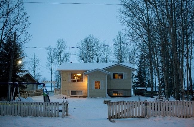 Police investigate a house Saturday, January 23, 2016 where two people were killed Friday before the shooting at the La Loche, Sask., junior and senior high school.
