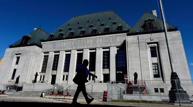 FILE PHOTO - A pedestrian walks past the Supreme Court of Canada in Ottawa on Thursday, July 23, 2015. 