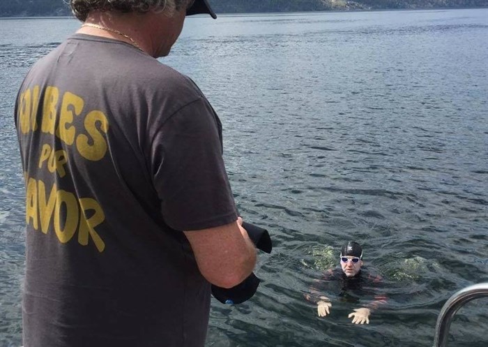 Adam Ellenstein, 39, is pictured during a break with one of his 20 support team members on his Okanagan Lake swim on Monday, July 25, 2016 in this Facebook photo. 