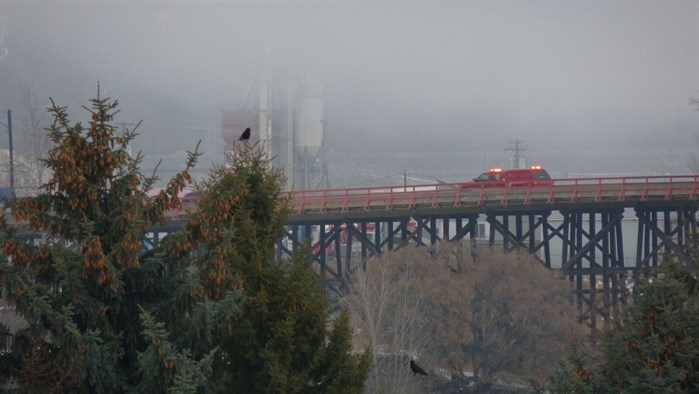 A Kamloops Fire Rescue truck is seen crossing the Red Bridge to reach the structure. 