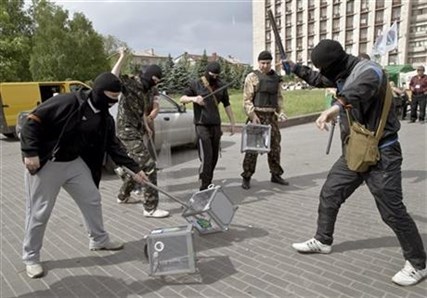Pro-Russian militants smash ballot boxes in front of the seized regional administration building in Donetsk, Ukraine, Sunday, May 25, 2014.