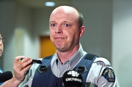 RCMP officer Damien Theriault holds back tears while addressing the media during a press conference at City Hall in Moncton, N.B. on Wednesday June 4, 2014.