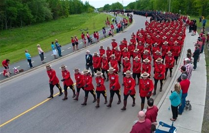 RCMP officers march in the funeral procession on their way to the regimental funeral for three slain RCMP officers in Moncton, N.B., Tuesday, June 10, 2014.