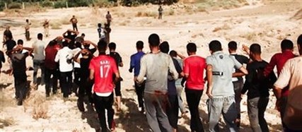 This image posted on a militant website on Saturday, June 14, 2014 appears to show militants from the al-Qaida-inspired Islamic State of Iraq and the Levant (ISIL) leading captured Iraqi soldiers wearing plain clothes to an open field moments before shooting them in Tikrit, Iraq.