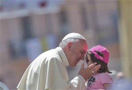 Pope Francis kisses a girl in front the Duomo of Cassano allo Jonio, southern Italy, Saturday, June 21, 2014.