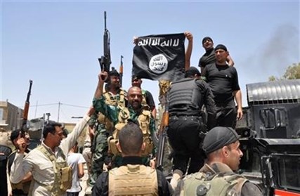 Iraqi security forces hold up a flag of the Islamic State in Iraq northeast of Baghdad, Iraq on Saturday, June 28, 2014.