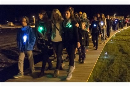Family and friends walk along the crash site, observing a moment of silence at 1:15 a.m. on Sunday, July 6, 2014 when a runaway train derailed in the centre of Lac-Megantic killing 47 people.