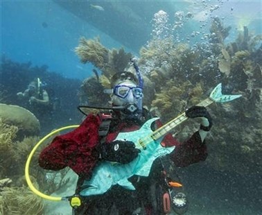 Mike Limerick pretends to play a mock musical instrument at the Lower Keys Underwater Music Festival on Saturday, July 12, 2014.