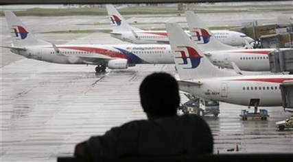 A visitor looks out from the viewing gallery as Malaysia Airlines aircrafts sit on the tarmac at the Kuala Lumpur International Airport.