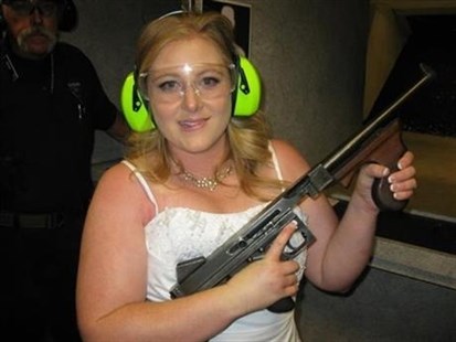 This July 28, 2012 file photo provided by Bob MacDuff shows Lindsae MacDuff holding an automatic weapon at the Gun store in Las Vegas after her 