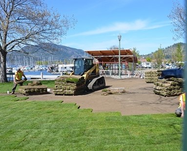 Construction workers lay out new turf around the future entrance point to Kelowna's new downtown pier.