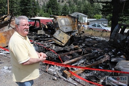 Robbie Kilborn of Olalla stands next to a destroyed Mercedes Benz. His brother's motor home and other vehicles were destroyed in a fire Sunday night.