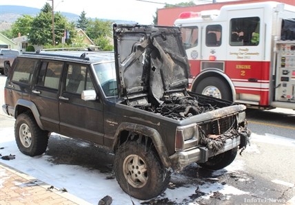 A Penticton Fire and Rescue truck speeds away after dousing a burning Jeep Cherokee Laredo on Padmore Avenue East Wednesday afternoon. RCMP remained on scene.