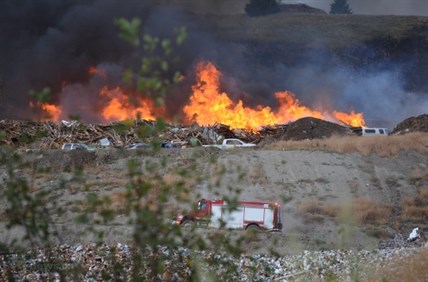 Flames rise after a wood grinder malfunctioned at the Vernon landfill and sparked a large fire which has spread to nearby grass. 