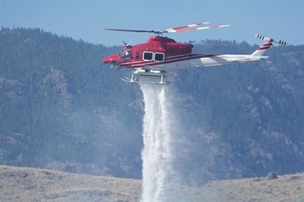 A helicopter drops water on the Cherry Creek wildfire.