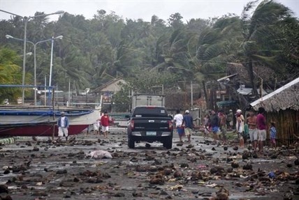 Debris litter the road by the coastal village in Legazpi city following a storm surge brought about by powerful Typhoon Haiyan.