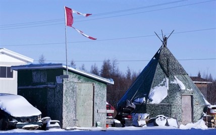 The remains of a Canadian flag can be seen flying over a building in Attawapiskat, Ont., on November 29, 2011.