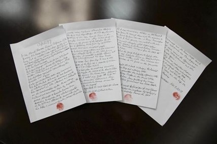 In this Nov. 9, 2013 photo released by the Korean Central News Agency (KCNA) and distributed Nov. 30, 2013 by the Korea News Service, hand written statements with red thumb prints, which North Korean authorities say is an apology written and read by 85-year-old U.S. citizen Merrill Newman, lie on a table in North Korea. Newman, an avid traveler and retired finance executive, was taken off a plane Oct. 26 by North Korean authorities while preparing to leave the country after a 10-day tour.