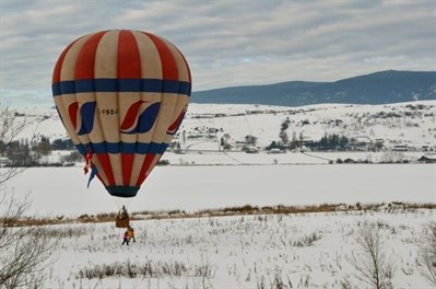 A hot air balloon lands beside Swan Lake.