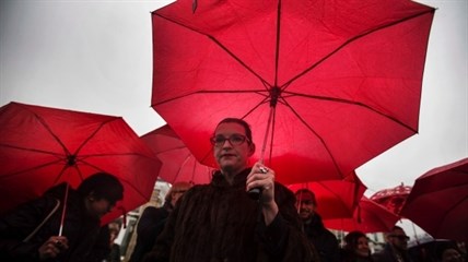 People hold red umbrellas, that are used as a symbol for sex workers rights, at a rally at Allan Gardens park to support Toronto sex workers and their rights in Toronto, Friday December 20, 2013.
