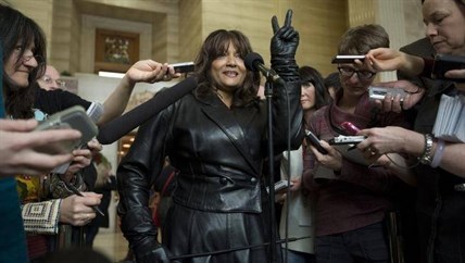 Terri-Jean Bedford flashes a victory sign as she speaks with the media after learning Canada’s highest court struck down the country’s prostitution laws at the Supreme Court of Canada in Ottawa on Dec. 20, 2013.