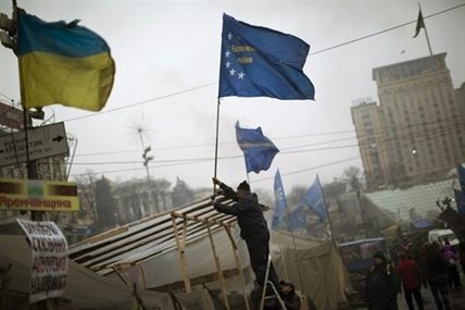 An anti-Yanukovych protester sets an European Union flag on top of a tent in Kiev's Independence Square, the epicenter of the country's current unrest, Ukraine, Sunday, March 2, 2014.