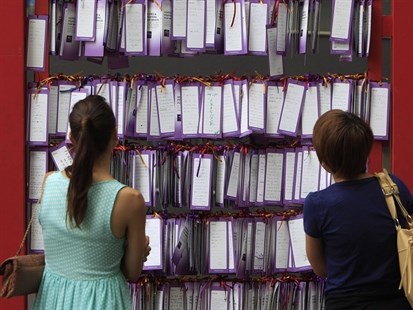 People read message cards tied up for passengers aboard a missing Malaysia Airlines plane, outside a shopping mall in Kuala Lumpur, Malaysia, Friday, March 14, 2014.