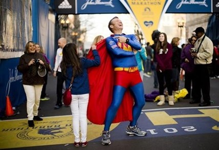 Trent Morrow of Sydney, Australia, also know as “Marathon Man” laughs as Andrea Olivo of Venezuela tugs on his cape as she has her photo made ahead of Monday's 118th Boston Marathon, Sunday, April 20, 2014, in Boston. Morrow says Monday's marathon will be his 200th run since Jan. 1, 2013.