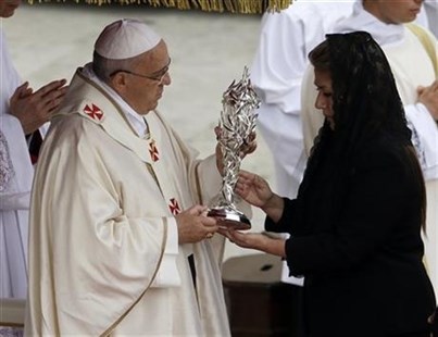 Pope Francis receives the relic of Pope John Paul II from Floribeth Mora, a Costa Rican woman whose inoperable brain aneurysm purportedly disappeared after she prayed to John Paul II, during a solemn ceremony in St. Peter's Square at the Vatican, Sunday, April 27, 2014.