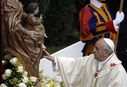 Pope Francis touches a statue of the Virgin Mary as he leads a solemn ceremony in St. Peter's Square at the Vatican, Sunday, April 27, 2014.