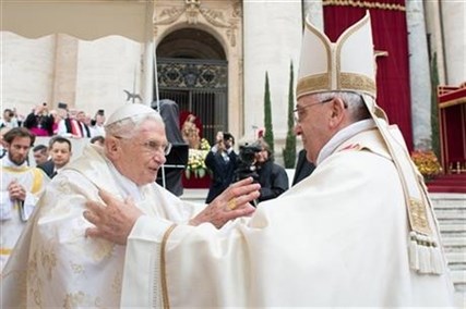 Pope Francis, right, embraces his predecessor Pope Emeritus Benedict XVI, during a ceremony in St. Peter's Square at the Vatican, Sunday, April 27, 2014.