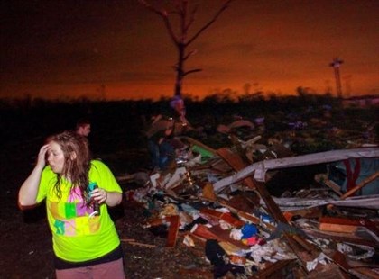 In this Sunday, April 27, 2014 photo, Lauren Watts searches for her dog in Mayflower, Ark., after a tornado struck the town. A tornado system ripped through several states in the central U.S. and left more than a dozen dead in a violent start to this year's storm season, officials said.