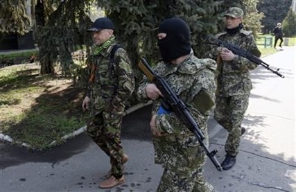 Vacheslav Ponomarev, left, the self-proclaimed mayor of Slovyansk, surrounded by bodyguards, walks in Slovyansk, eastern Ukraine, Saturday, May 3, 2014.